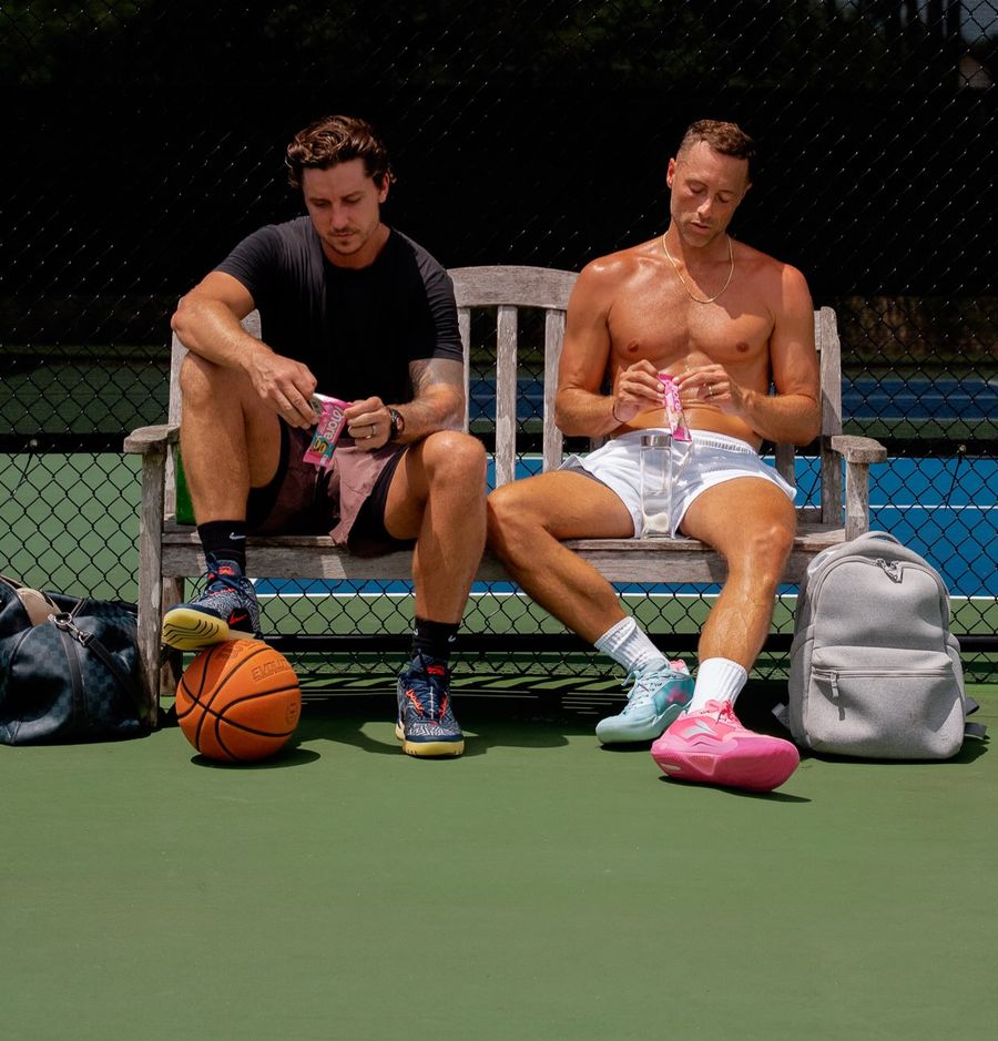 Kurt Benkert and a training partner on a courtside bench opening More packs.